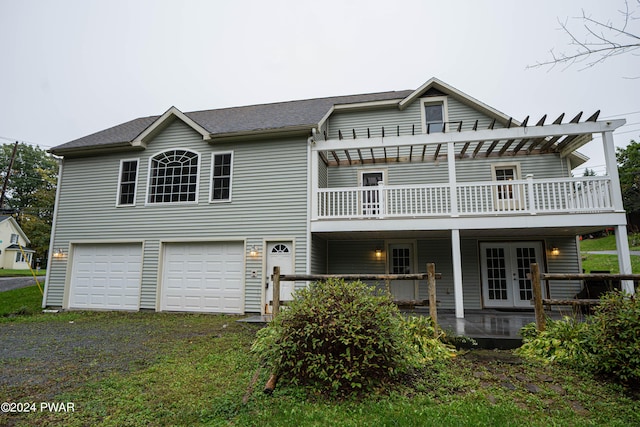 back of property with a garage, a pergola, and french doors