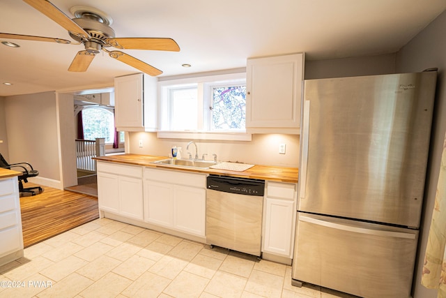 kitchen featuring white cabinets, sink, ceiling fan, butcher block counters, and stainless steel appliances