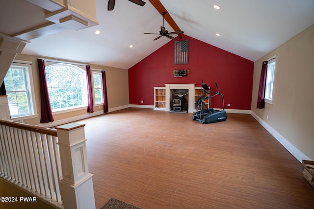 unfurnished living room featuring a wood stove, ceiling fan, and lofted ceiling