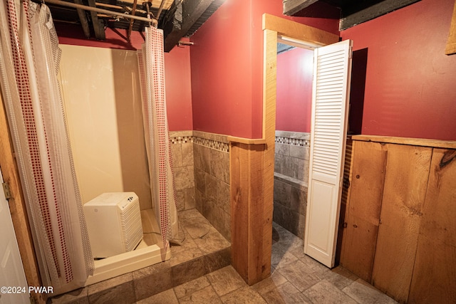 bathroom with tile walls and curtained shower