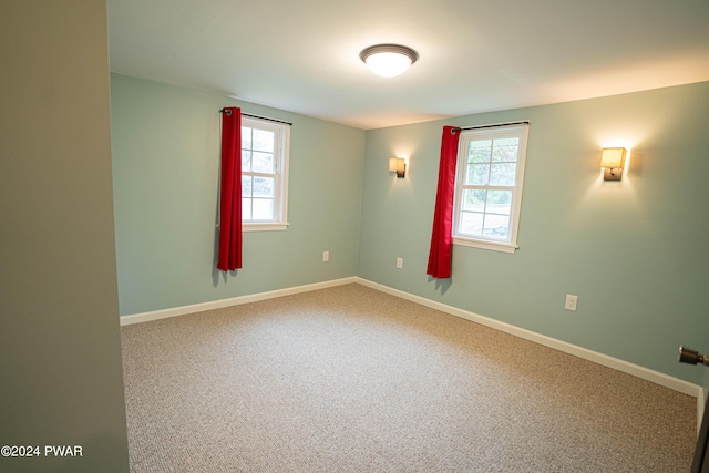 carpeted empty room featuring a wealth of natural light