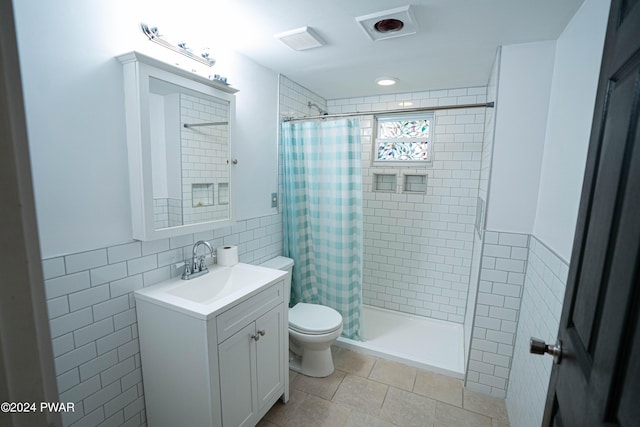 bathroom featuring vanity, toilet, tile walls, and walk in shower