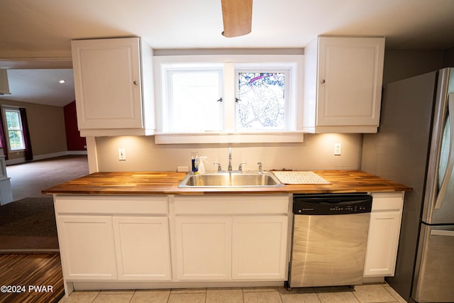 kitchen featuring appliances with stainless steel finishes, white cabinetry, butcher block counters, and sink