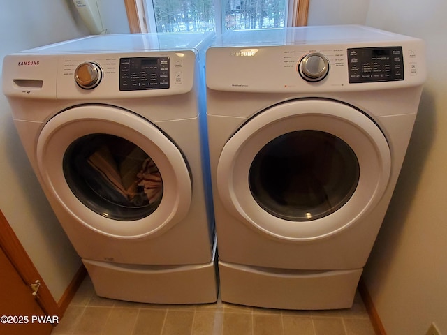 laundry room featuring light tile patterned flooring and separate washer and dryer