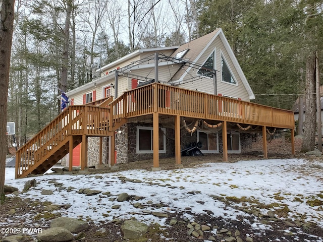 snow covered rear of property featuring a deck