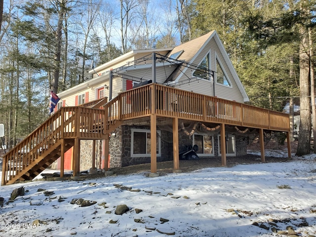 snow covered rear of property featuring a deck