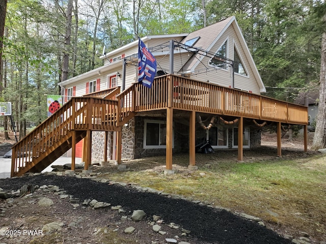 rear view of property featuring stairway, a deck, and stone siding