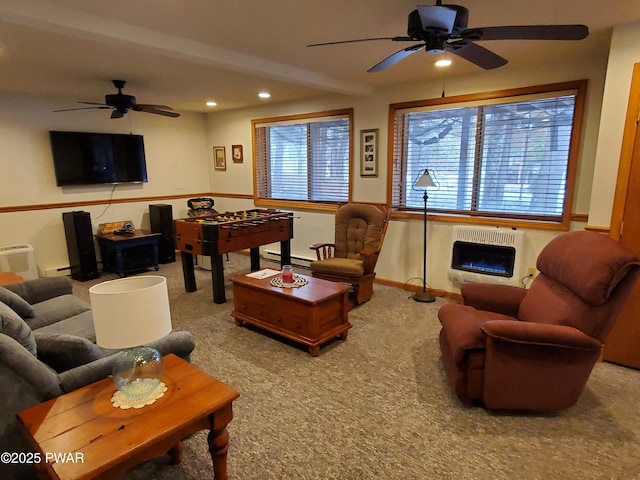 carpeted living room featuring ceiling fan, heating unit, a fireplace, and a baseboard radiator