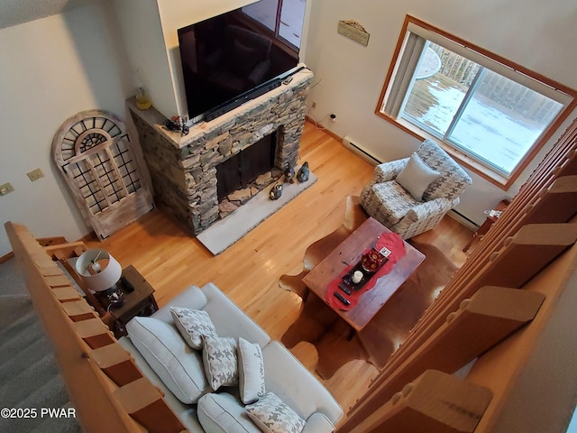 living room with wood-type flooring, a fireplace, and baseboard heating