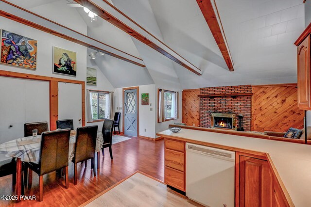 3218 Bluebird Dr, Bushkill, PA 18324 - kitchen featuring white dishwasher, light wood-type flooring, open floor plan, a fireplace, and light countertops
