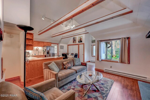 3218 Bluebird Dr, Bushkill, PA 18324 - living area with a baseboard radiator, vaulted ceiling, light wood-style flooring, and a ceiling fan