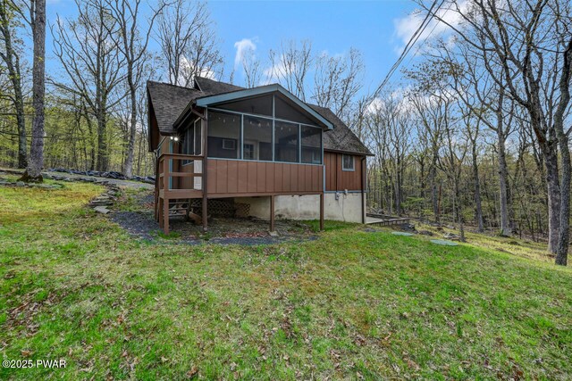 3218 Bluebird Dr, Bushkill, PA 18324 - back of house featuring a sunroom, a lawn, and a shingled roof