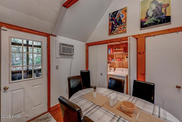 3218 Bluebird Dr, Bushkill, PA 18324 - dining room featuring washing machine and clothes dryer, an AC wall unit, vaulted ceiling, wood finished floors, and an office area