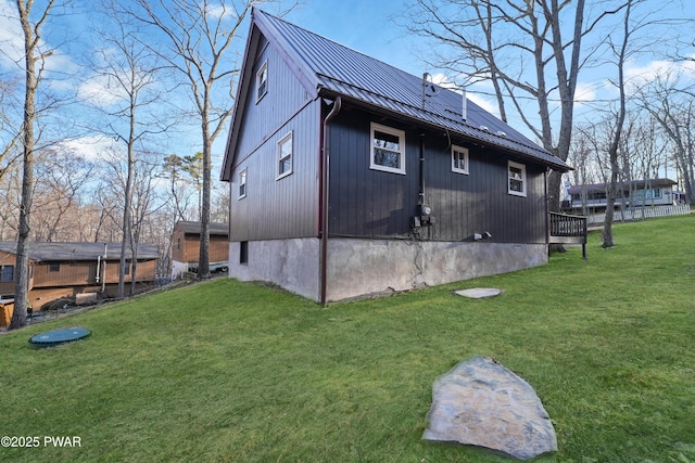 view of side of home with a yard and metal roof