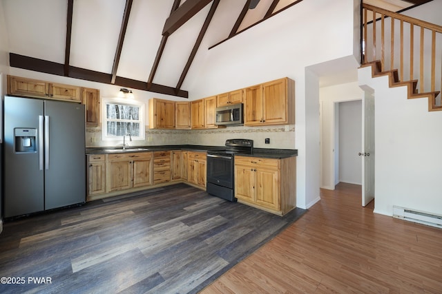 kitchen featuring decorative backsplash, dark countertops, dark wood-style floors, appliances with stainless steel finishes, and a baseboard radiator