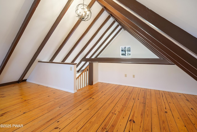 bonus room with a notable chandelier, vaulted ceiling with beams, baseboards, and wood-type flooring