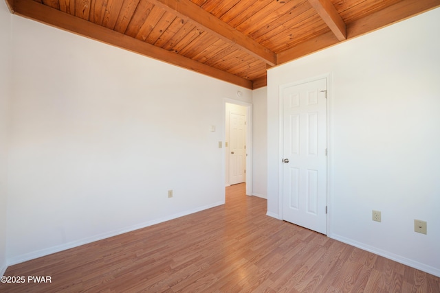 unfurnished room featuring wood ceiling, beamed ceiling, baseboards, and light wood-type flooring