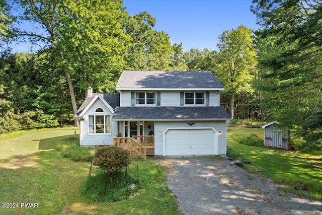 view of front facade featuring a front yard, a garage, a storage unit, and covered porch