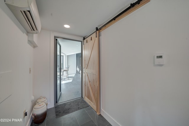 corridor featuring an AC wall unit and a barn door