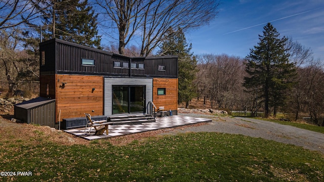 back of property with a lawn and a patio area