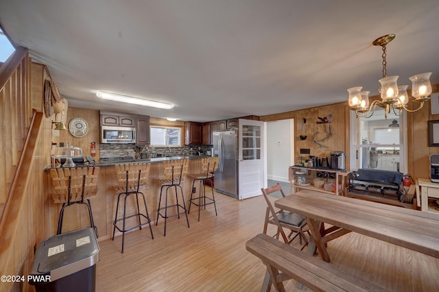 dining space with light hardwood / wood-style floors, an inviting chandelier, and sink