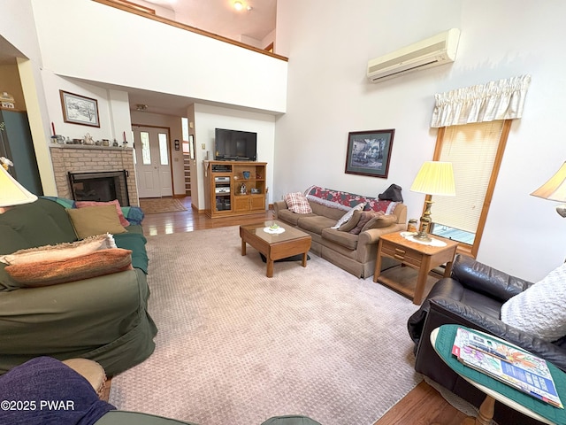 living room with a wall mounted AC, wood finished floors, and a fireplace