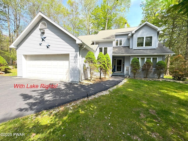 view of front of home featuring driveway, a front yard, and a garage