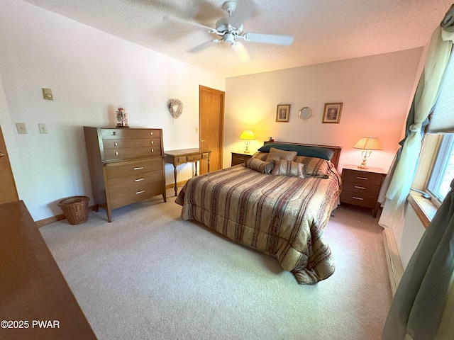 bedroom featuring light carpet, ceiling fan, and a textured ceiling
