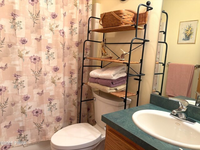 bathroom featuring toilet, vanity, and a shower with curtain