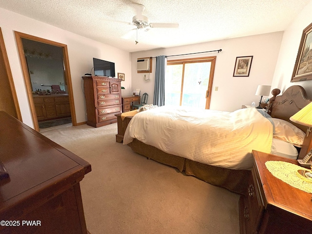 carpeted bedroom with a wall mounted AC, access to outside, ceiling fan, ensuite bath, and a textured ceiling