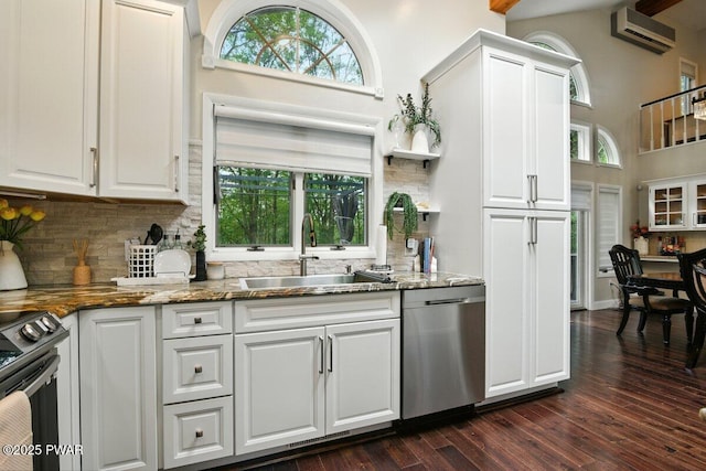 202 Remuda Dr, Lords Valley, PA 18428 - kitchen with appliances with stainless steel finishes, an AC wall unit, decorative backsplash, high vaulted ceiling, and white cabinetry
