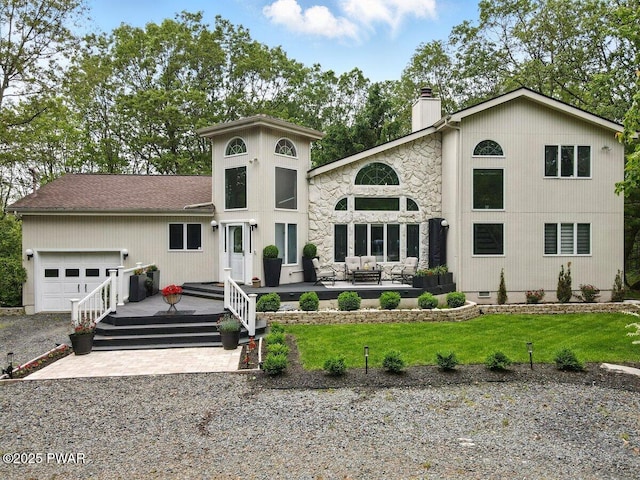 202 Remuda Dr, Lords Valley, PA 18428 - view of front of house featuring an attached garage, outdoor lounge area, a chimney, stone siding, and driveway