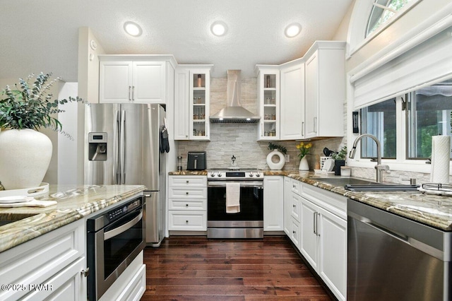 202 Remuda Dr, Lords Valley, PA 18428 - kitchen featuring stainless steel appliances, wall chimney exhaust hood, light stone counters, tasteful backsplash, and white cabinets