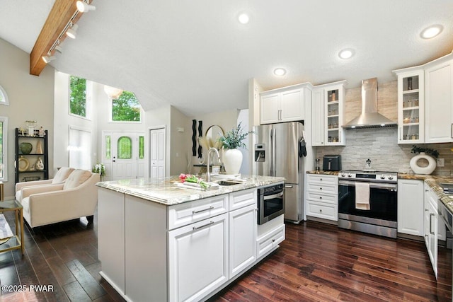 202 Remuda Dr, Lords Valley, PA 18428 - kitchen with wall chimney exhaust hood, stainless steel appliances, dark wood finished floors, decorative backsplash, and rail lighting
