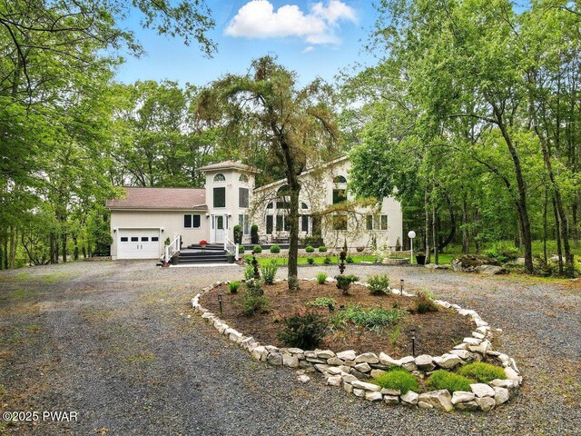 202 Remuda Dr, Lords Valley, PA 18428 - view of front facade featuring gravel driveway, a garage, and stucco siding
