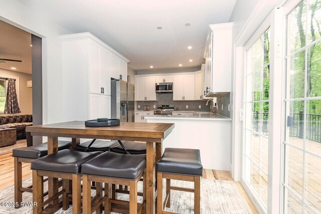 209 Conashaugh Trl, Milford, PA 18337 - kitchen featuring appliances with stainless steel finishes, backsplash, white cabinets, and healthy amount of natural light