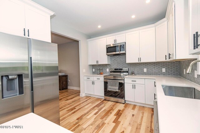 209 Conashaugh Trl, Milford, PA 18337 - kitchen with stainless steel appliances, light countertops, backsplash, white cabinetry, and recessed lighting