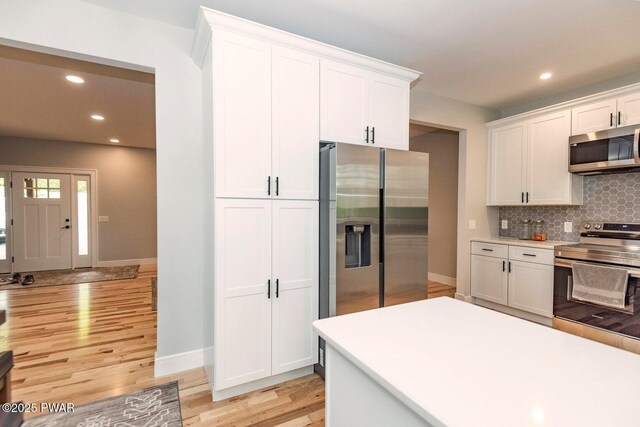 209 Conashaugh Trl, Milford, PA 18337 - kitchen featuring appliances with stainless steel finishes, white cabinets, backsplash, recessed lighting, and light wood-style floors