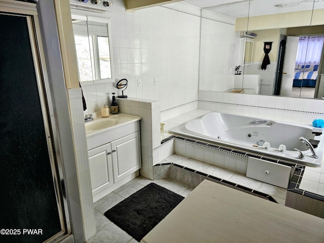 bathroom with tile patterned floors, vanity, tile walls, and shower with separate bathtub