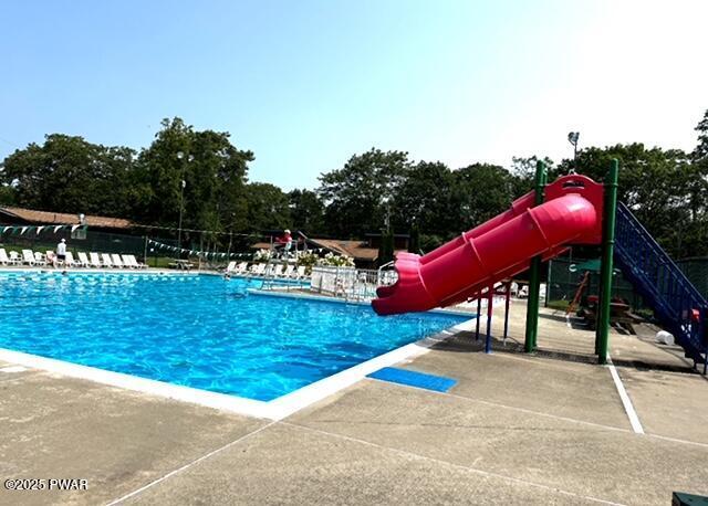 124 Granite Dr, Lords Valley, PA 18428 - community pool featuring a water slide, view of scattered trees, and a patio