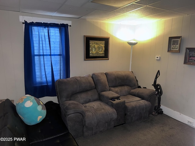 living room featuring a drop ceiling and carpet floors