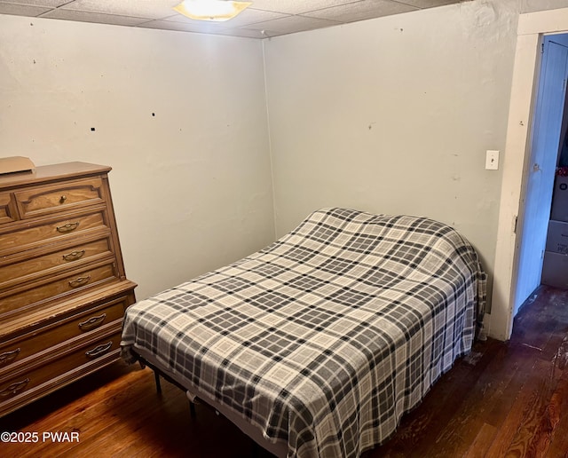 bedroom with dark hardwood / wood-style floors and a paneled ceiling