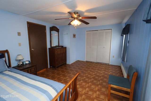 bedroom featuring a closet, baseboard heating, and a ceiling fan