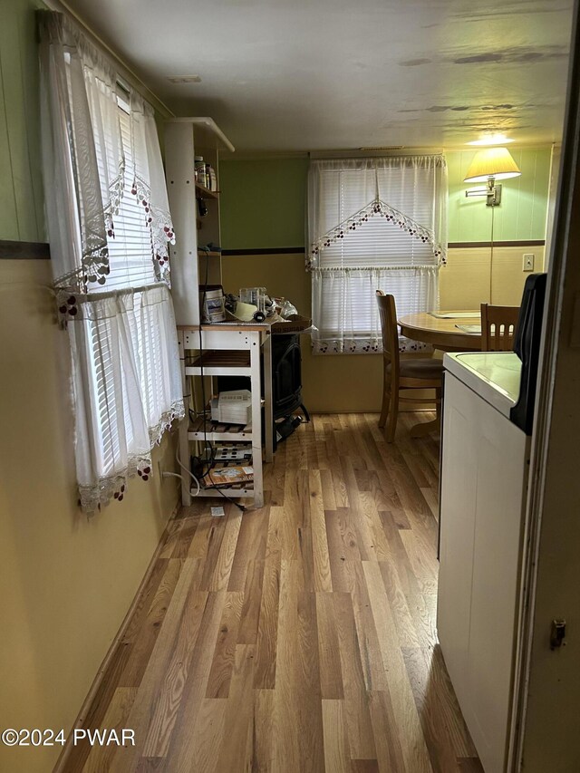 interior space featuring a healthy amount of sunlight, wood-type flooring, and washer / dryer