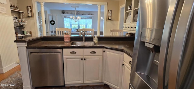 300 W High St, Milford, PA 18337 - kitchen featuring appliances with stainless steel finishes, dark countertops, white cabinets, a chandelier, and a wainscoted wall