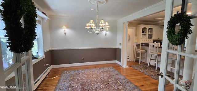 300 W High St, Milford, PA 18337 - dining space with a baseboard radiator, wood finished floors, a chandelier, and ornamental molding