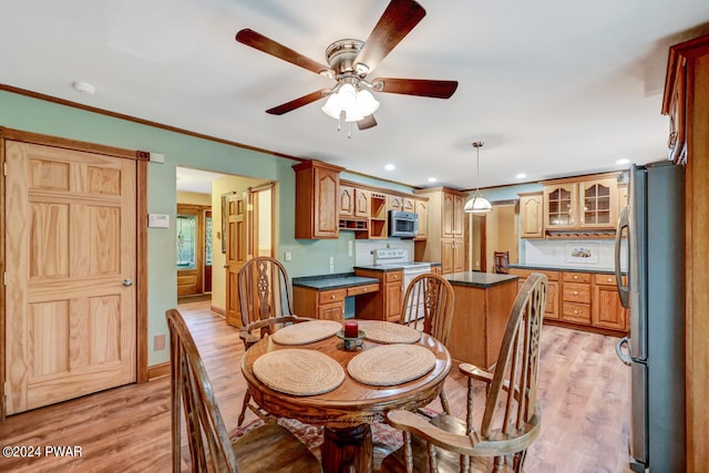 dining room featuring ceiling fan, light hardwood / wood-style flooring, and crown molding