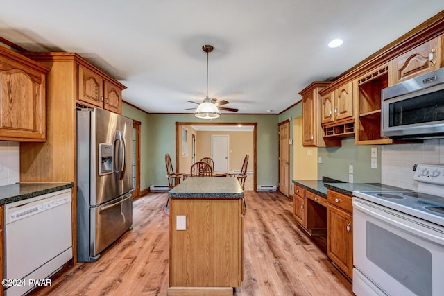 kitchen featuring appliances with stainless steel finishes, a center island, light hardwood / wood-style flooring, and backsplash