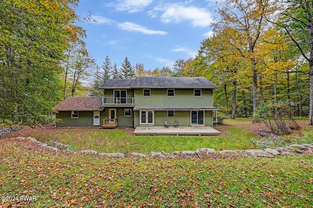 rear view of property featuring a wooden deck and a yard