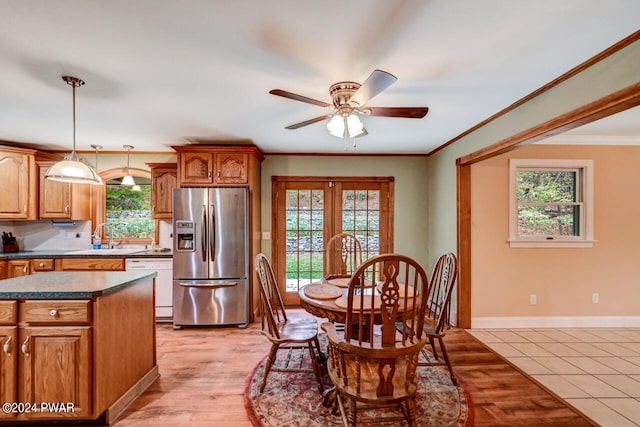 kitchen with pendant lighting, a center island, white dishwasher, sink, and stainless steel fridge with ice dispenser